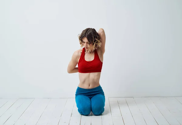 En kvinna i sportkläder gör yoga i ett ljust rum och gestikulerar med händerna — Stockfoto