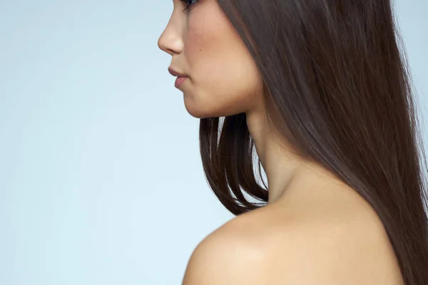 Frau mit nackten Schultern lange Haare saubere Haut abgeschnitten Ansicht blauer Hintergrund — Stockfoto