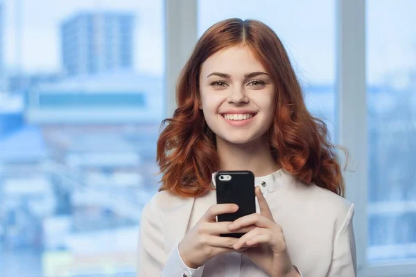 Жінка в сорочці з телефоном в руці технології професіонал — стокове фото