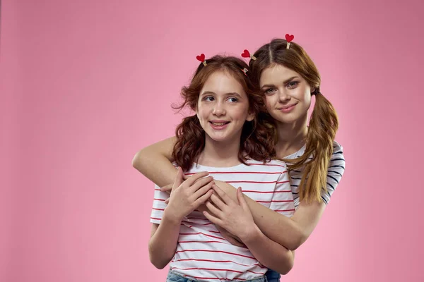 Γυναίκα και μικρό κορίτσι σε ροζ φόντο διασκέδαση αδελφές φίλους οικογένεια — Φωτογραφία Αρχείου