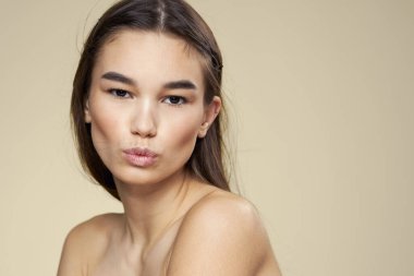 Güzel kadın çıplak omuzlar uzun saç bakımı bej arka plan