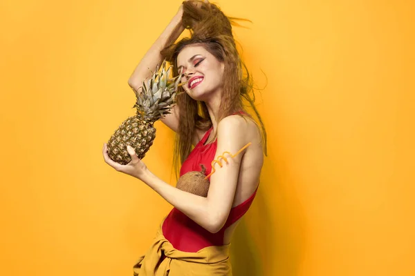 Vacker kvinna med ananas i händerna kosmetika exotiska frukter gul bakgrund kul — Stockfoto