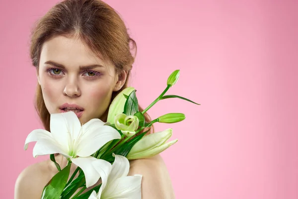 Piękna kobieta z kwiatami na różowym tle makijaż portret model — Zdjęcie stockowe
