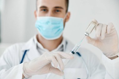 Elinde şırınga olan doktor Coronavirus aşısı tıbbi elbise maske aşısı