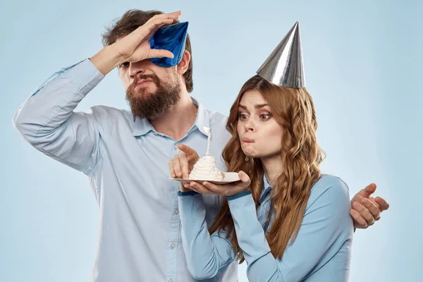 Cheerful man and woman with cake in a plate corporate party blue background — Stock Photo, Image