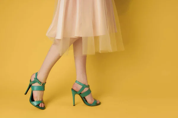 Pés femininos sapatos verdes estilo elegante sapatos de fundo amarelo — Fotografia de Stock