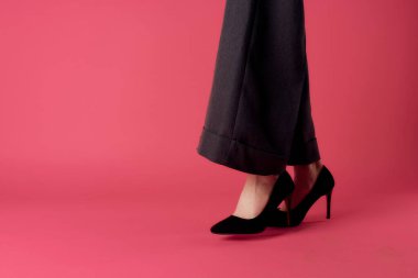 Kadın bacakları siyah ayakkabılar büyüleyici lüks pembe arka plan kırpılmış manzara