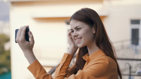 Cheerful woman in nature with phones in her hands shoots on camera — Stock Photo, Image