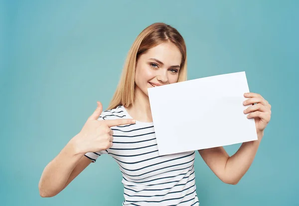 Gelukkig blond meisje in gestreepte t-shirt banner wit vel papier mockup — Stockfoto