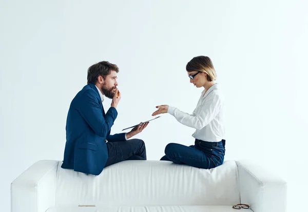 Woman and man are sitting on the couch in suits documents psychology staff