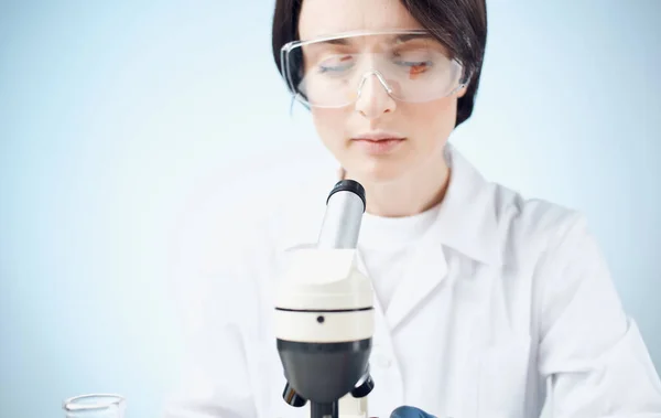 I medici in guanti medici guardano attraverso un microscopio sul tavolo e laboratorio elemento chimico vaccino — Foto Stock