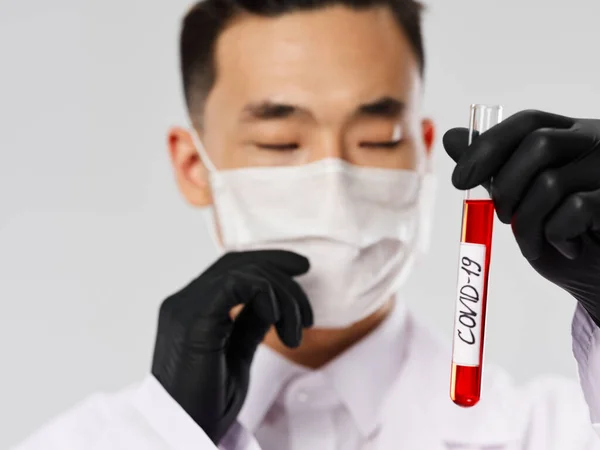 Людина азіатського виду захисна маска Аналіз крові на близькому сірому фоні — стокове фото
