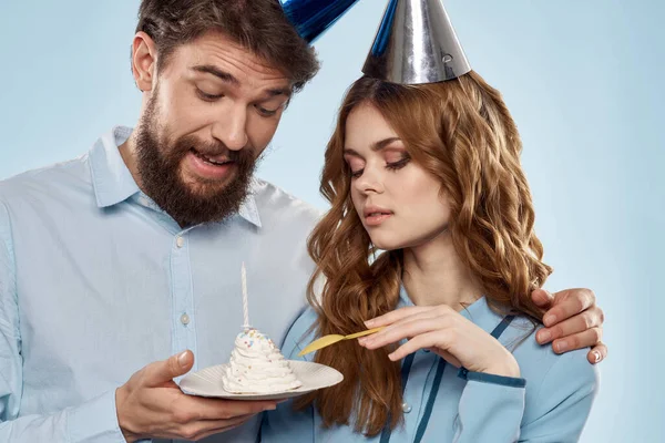Mutlu bir adam ve kadın bir tabak kek ile şirket mavi arka planda — Stok fotoğraf