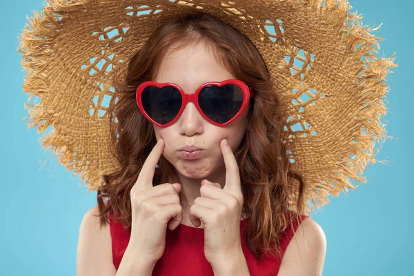 Chica en una playa Sombrero de paja en gafas de sol pelo rizado divertido fondo azul — Foto de Stock