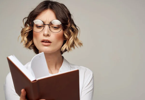 Femme alphabétisée avec livre dans les mains et dans les lunettes modèle d'éducation chemise blanche — Photo