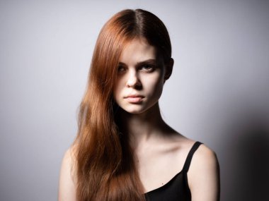 Siyah tişörtlü zarif bayan. Kızıl saçlı, üzgün surat.