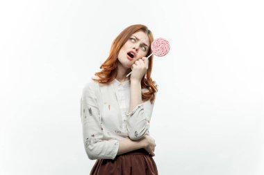 Ellerinde lolipopları olan kızıl saçlı güzel bir kadın. 