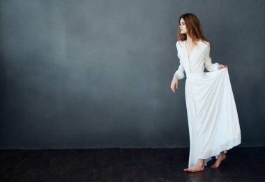 Beyaz elbiseli kadın gri arka planda kızıl saç modeli romantizm kopyalama alanı