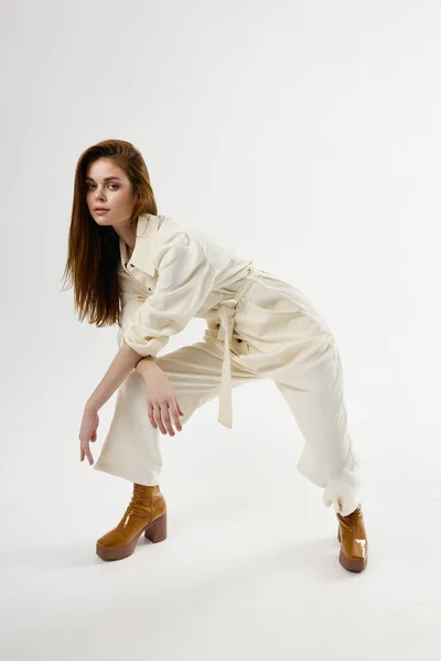 Модна жінка нахилилася вперед білий комбінезон студії сучасного стилю ізольований фон — стокове фото