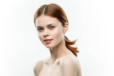 Güzel kadın çıplak omuzlar makyaj malzemesi topladı. Saçlar çekici görünüyor.