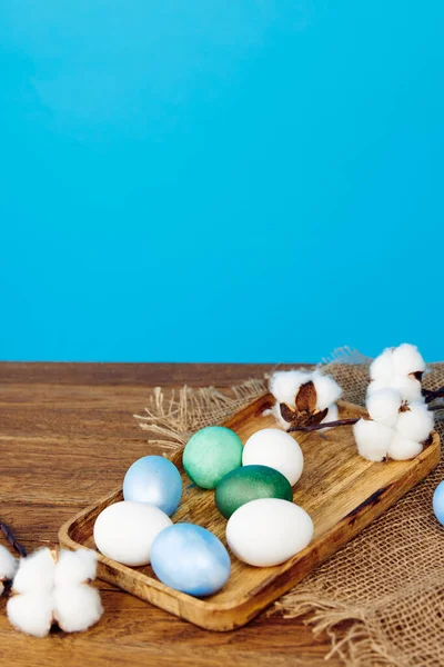 Huevos de colores en la celebración del tablero de madera decoración de dinero cristiano —  Fotos de Stock