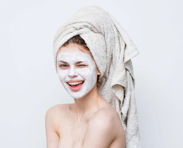 Woman with bare shoulders face cream towel on head — Stock Photo, Image