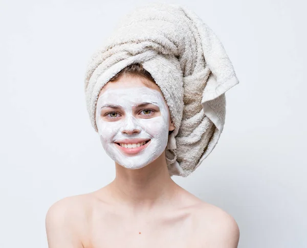 Happy woman with white mask on her face naked shoulders clean skin towel on head — Stock Photo, Image