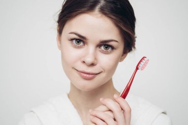 Sabahları beyaz bornozlu ucuz kadın diş fırçası hijyeni.