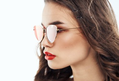 Açık arkaplanda kahverengi gözlüklü, zarif esmer kadın.