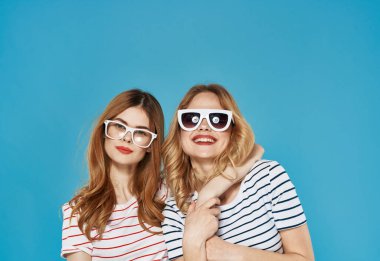 Çizgili tişörtlü iki neşeli kız arkadaş. Güneş gözlükleri. Arkadaşlık yaşam tarzı.