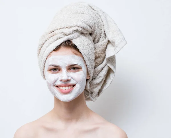 Wanita telanjang dengan krim putih di wajahnya dan handuk di kepalanya — Stok Foto