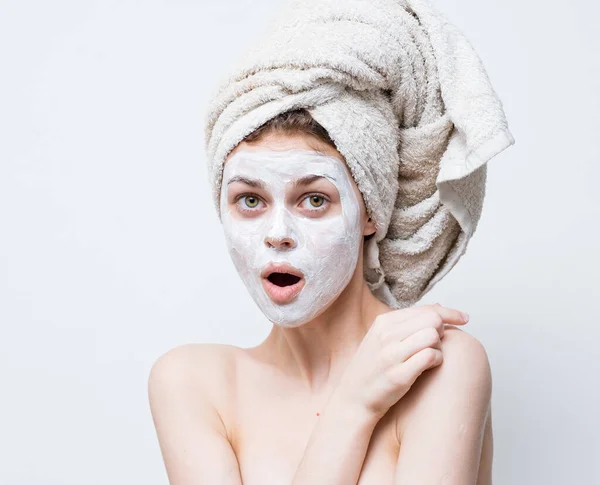 Pretty woman with a towel on her head and a white mask against black dots on her face — Stock Photo, Image