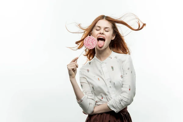 하얀 셔츠를 입고 사탕 사탕을 손에 쥐고 있는 여자 — 스톡 사진