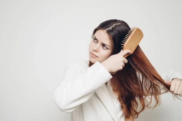 Perda de cabelo problemas de saúde mulher com um pente na mão em um fundo leve — Fotografia de Stock