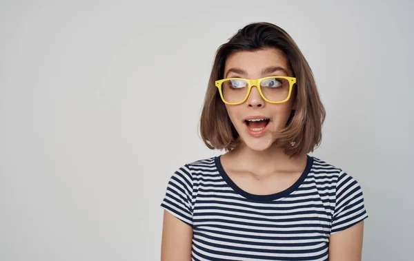 Portret van een vrouw met bril en een gestreept t-shirt op een grijze achtergrond mode stijl rode rok — Stockfoto