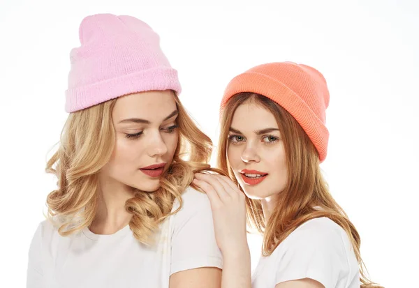 Amici di sesso femminile in cappelli multicolori abbracci stomaco gioia luce sfondo primo piano — Foto Stock