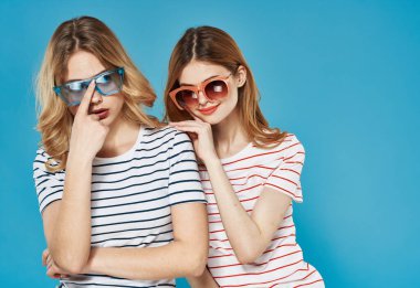 İki kadın modaya uygun kıyafetler. Koyu gözlükler. İletişim.