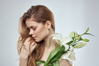 Açık arkaplanda beyaz çiçekli güzel bir kadının portresi.