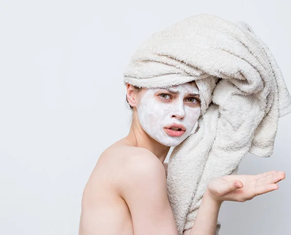 Mujer divertida con toalla en la cabeza desnuda hombros máscara blanca en la cara — Foto de Stock