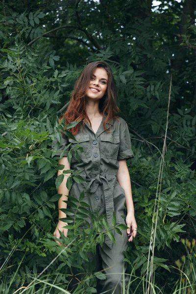 Mujer en el bosque hermosa sonrisa en verde mono de viaje —  Fotos de Stock