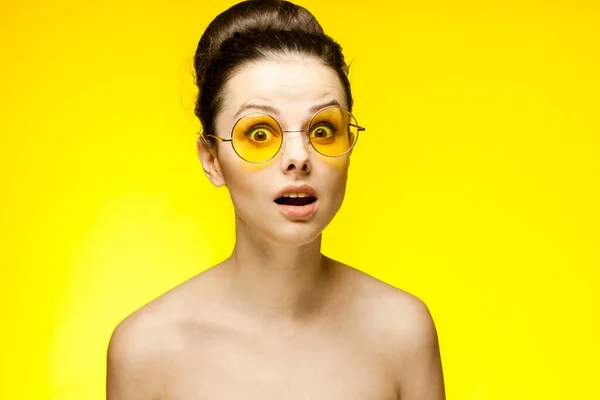 Красивая женщина с голыми плечами эмоции модные желтые очки обрезанный вид — стоковое фото