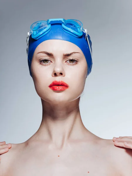 Femme en lunettes bleues bonnet de natation épaules nues fond clair — Photo