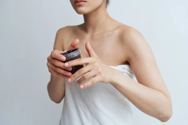 Kvinna i handduk bared axlar svart kräm i ren hud händer — Stockfoto