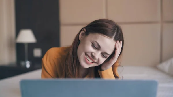 Glimlachende vrouw liggend in de voorkant van laptop internet vrije tijd communicatietechnologie — Stockfoto