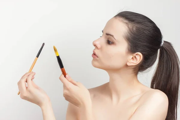 Brunette with cream face mask skin care brush applying makeup — Stock Photo, Image