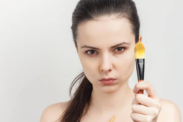 stock image brunette brushing cream on face skin care cropped view