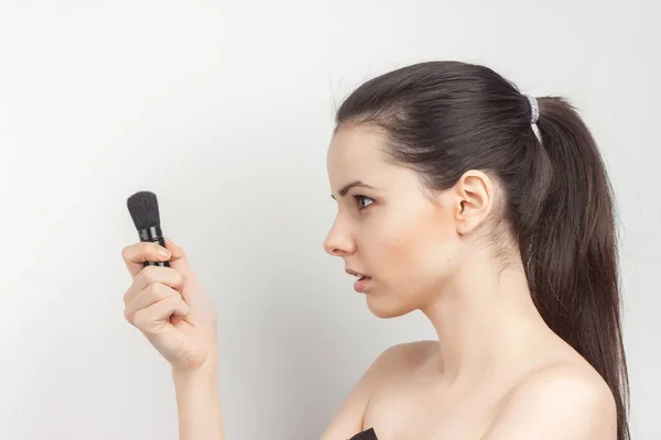 Frau mit nackten Schultern schminkt sich auf Gesichtsbehandlung — Stockfoto