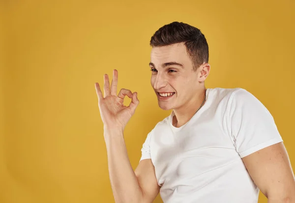 Energetischer Mann auf gelbem Hintergrund zeigt seine Finger zur Seite der Emotion Modellspaß — Stockfoto