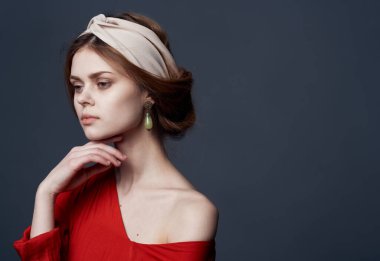 Kırmızı elbiseli güzel bir kadın. Gri arka planında lüks etnik türban var.