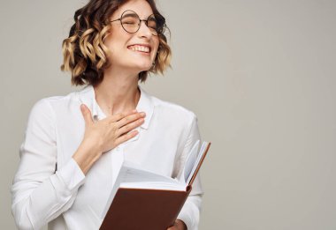 Gri arka planı olan, el hareketleriyle ofis eğitimi alan bir kadın.